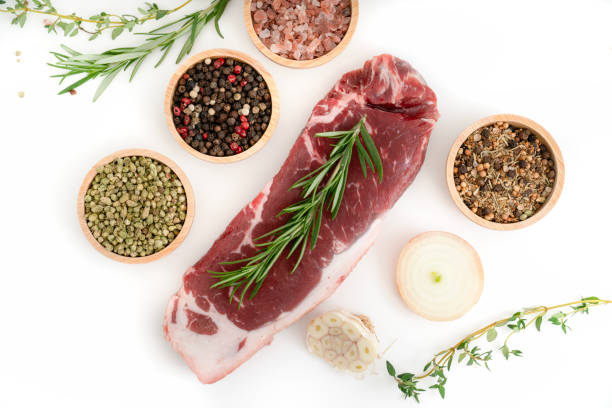 Slice of beef steak with spices isolated on white background.