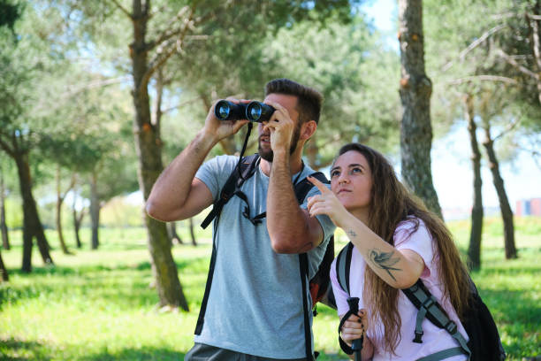 istock A man and a woman are looking through binoculars in a park 2153641708