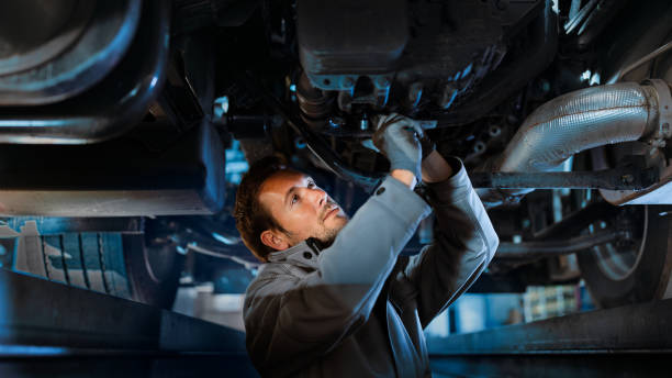 Truck mechanic is checking safety under of truck.