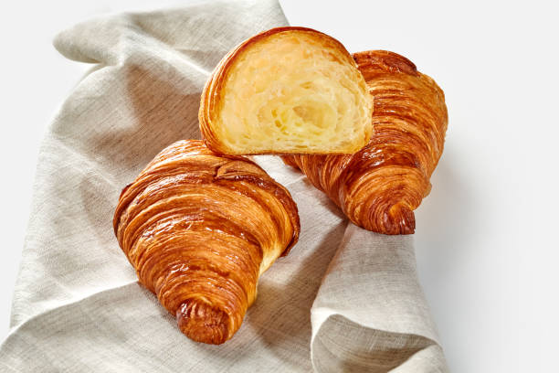 Traditional flaky French croissants on woven linen cloth