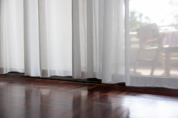 The curtains are white and the room is very bright. The curtains are open, letting in a lot of light
