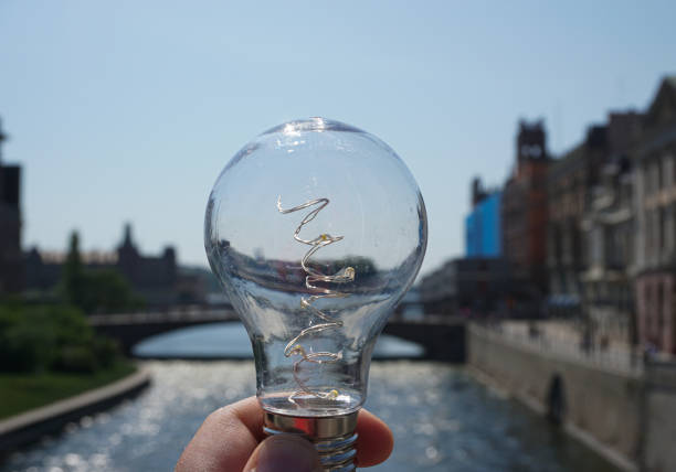 Cropped hand holding a light blub outdoors