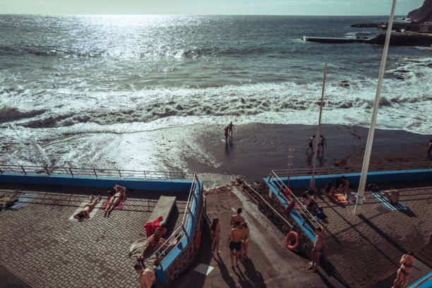 Galdar, Spain, March 29, 2024: People by the sea at bathing facilities during a sunny spring day on March 29, 2024 in Puerto de Sardina, Galdar, Gran Canaria, Canary Islands, Spain.
