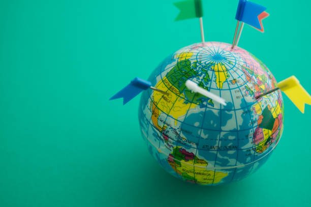 Color flag pins marks on earth globe with green color background copy space.