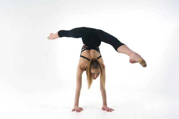 istock young gymnast in a photo studio shows stretching while doing splits while standing on her hands 2153657142