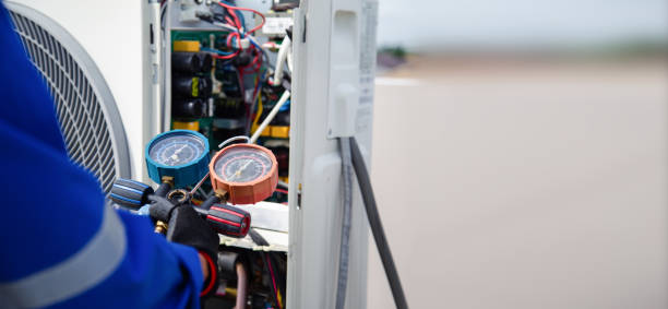 istock Air conditioner service .The air conditioner technician is using a gauge to measure the refrigerant pressure. air compressor. 2153661033