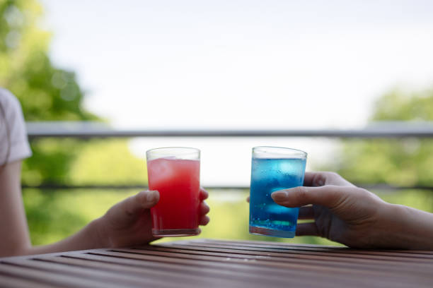 Hands of parent and child drinking colorful drinks