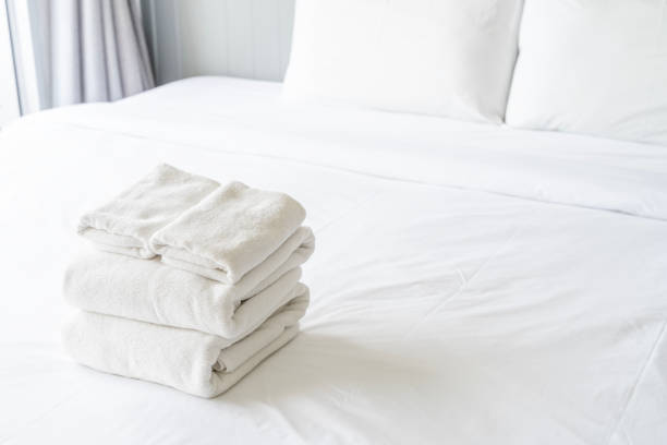 istock A stack of white towels on a bed. The towels are neatly folded and arranged in a pyramid shape. 2153662903