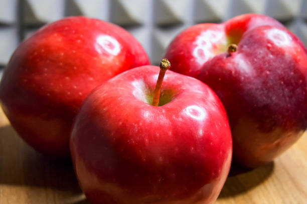 istock Glossy Apples. Apples with a shiny finish against a dark patterned background. 2153664428