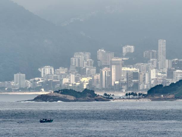 A beach with small fishing boats in the foreground, in Rio de Janeiro, pictured from offshore in the South Atlantic Ocean