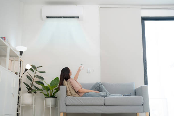 Young woman enjoying air conditioning at home
