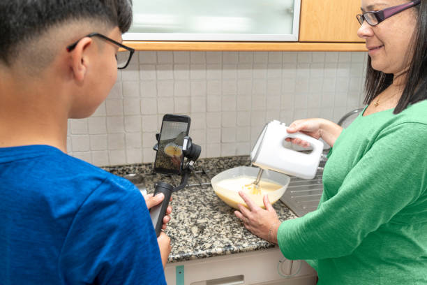 istock Child Filming Mother Baking Cake for Social Media 2153674345