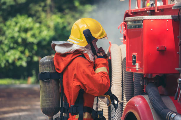 istock Fireman prepare equipment fighting extinguisher at fire engine truck. Firefighter fighting with smoke flame using fire hose, tube, chemical water foam spray at truck. Fireman wear hard hat protection 2153675818