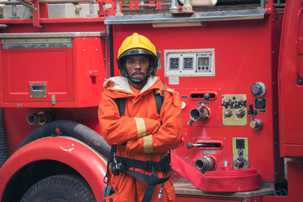 istock Fireman prepare equipment fighting extinguisher at fire engine truck. Firefighter fighting with smoke flame using fire hose, tube, chemical water foam spray at truck. Fireman wear hard hat protection 2153675843