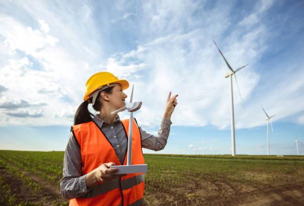 istock Woman engineer looking at wind turbine farm 2153675899