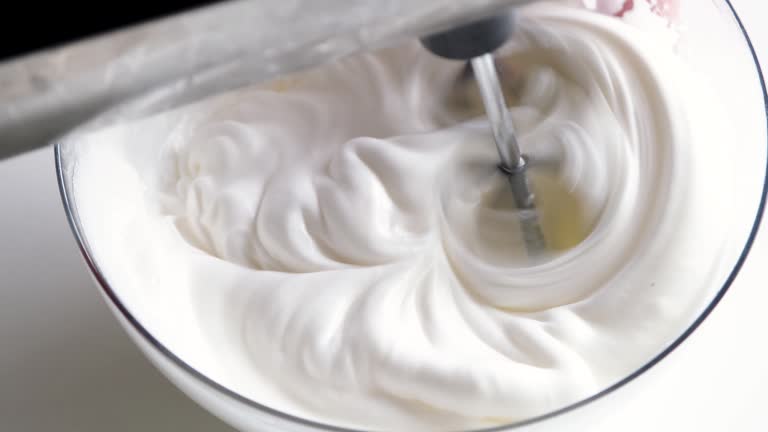 electric mixer whipping egg whites for cream, slow motion