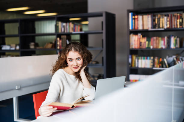 istock Young female student in library, focusing on final project, presentation. University student preparing for final exam. 2153693115