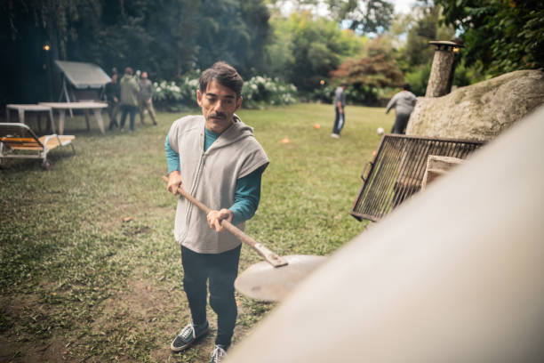 Mature man preparing pizza on a house yard