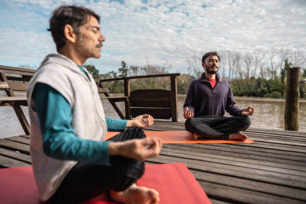 istock Young man meditating on the pier outdoors 2153693813