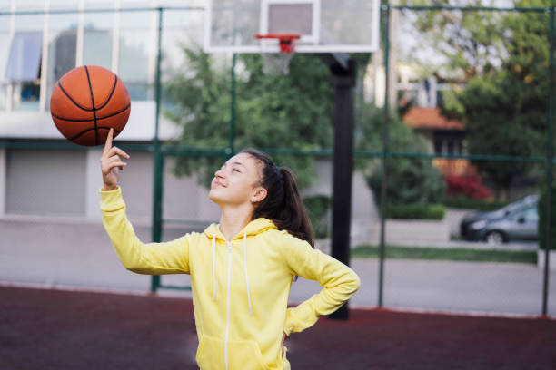 istock Girl spinning basketball on finger. 2153698374