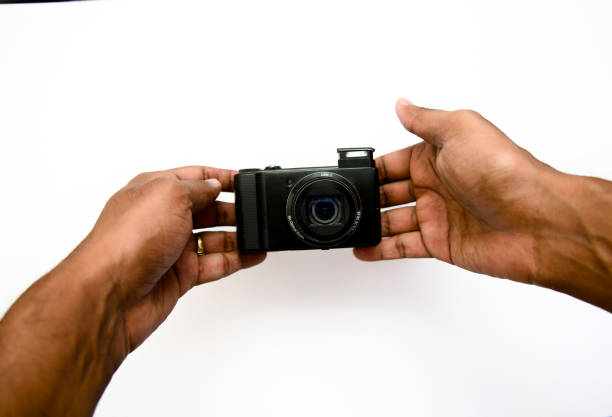 istock Mans hands holding a camera on a white background isolated 2153699356