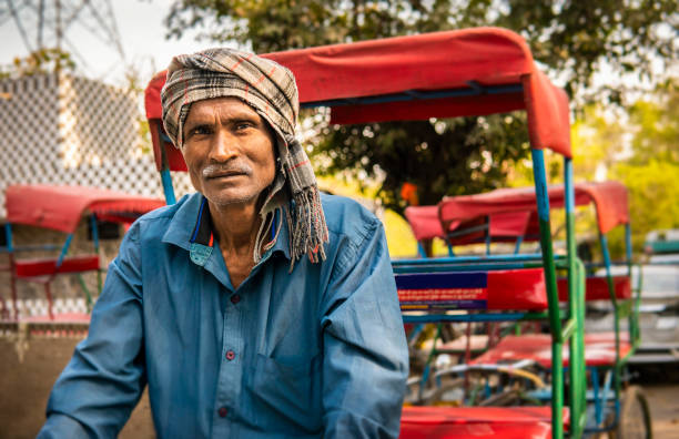 istock Portrait indian senior man tricycle rickshaw driver looking at the camera. 2153699790