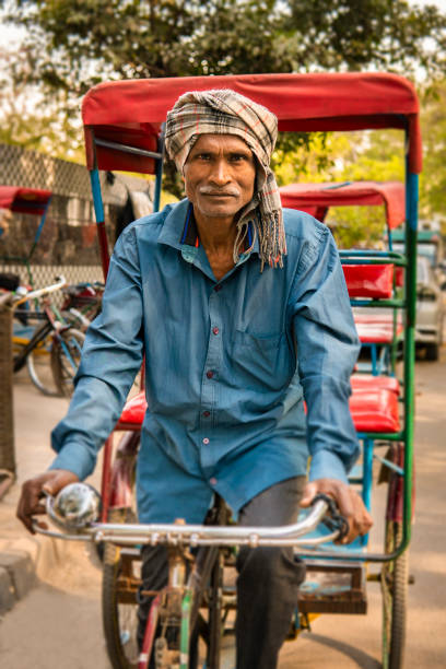 istock Portrait indian senior man tricycle rickshaw driver looking at the camera. 2153699796