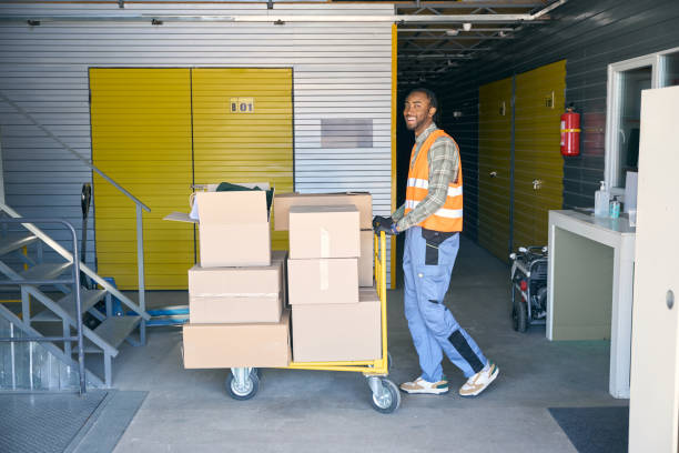 istock Freight handler transporting goods on wheeled cart in warehouse 2153700839