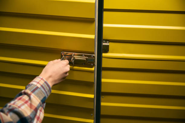 istock Warehouse employee is closing metal storage unit door 2153700867