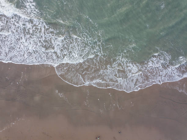 Aerial view of Ocean Beach surf looking straight down with birds eye view of the sand and water line.