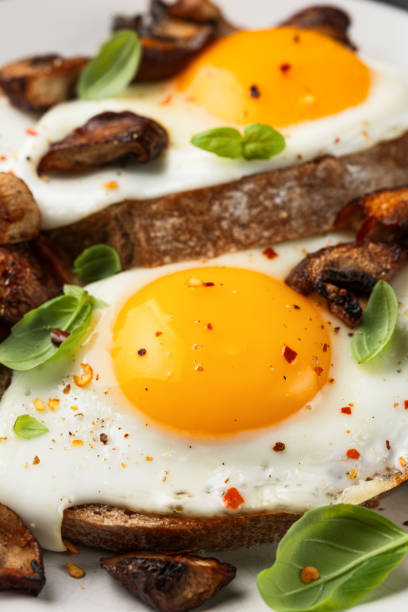 istock Mushrooms and fried eggs on toast with herbs breakfast 2153707422