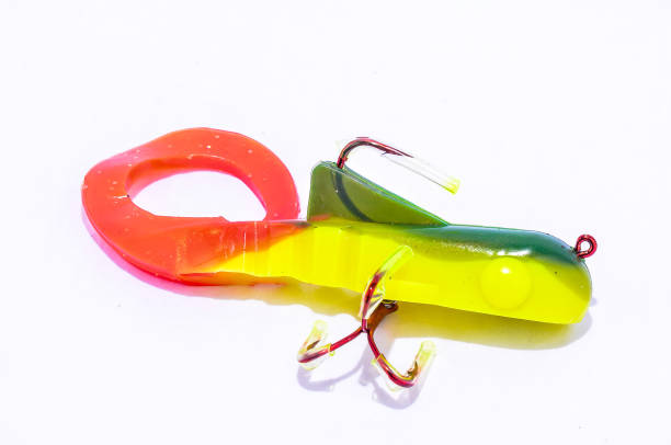 A colorful plastic fish lure with a hook on the end. The colors are red, yellow, and green