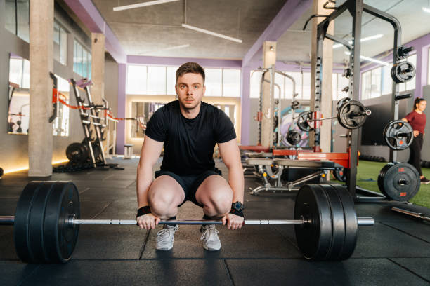 istock Young man body builder lifting heavy dumbbells at the gym 2153715107