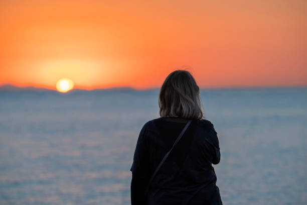 istock Woman watches sunset 2153717758