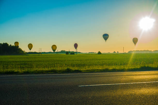 hot air balloon flying over the road