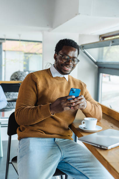 istock African American young man using smart phone and laptop in co-working space 2153719778