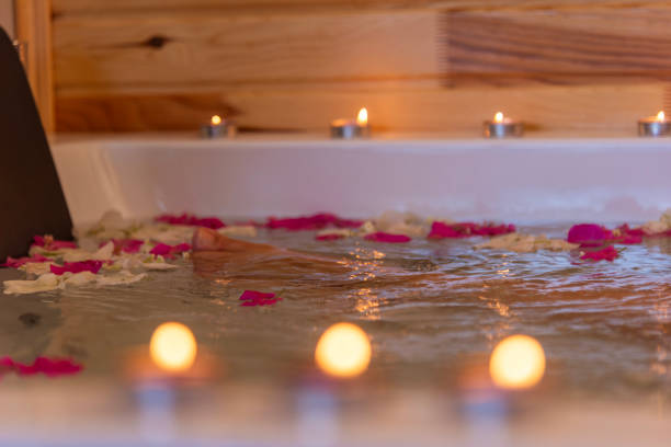 istock Spa treatment hat tub with floating rose petals and red candle 2153720491
