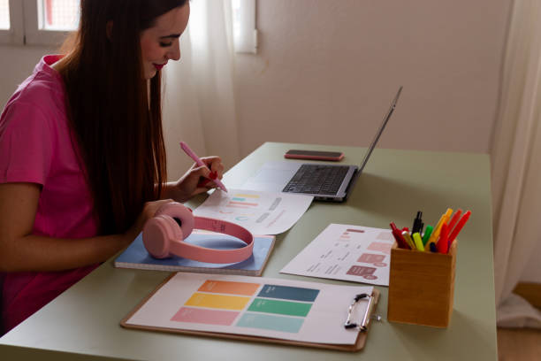 istock Young woman working from home with laptop and documents 2153727089