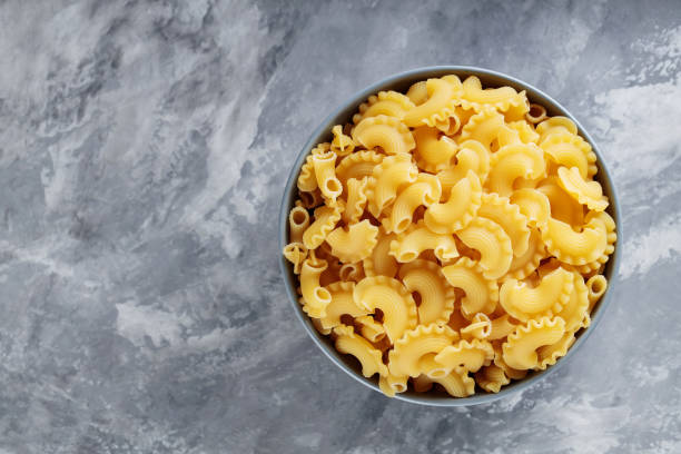 istock Raw Creste di Gallo Pasta in Ceramic Bowl on Concrete Background, Copy Space 2153728427