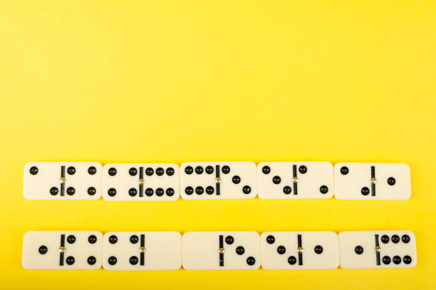 Dominoes with yellow background, copy space and various angles, board games concept