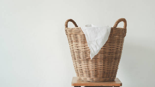 istock Wicker laundry basket with clean clothes with copy space on a wood table against the white background. Space for text or product. 2153734174