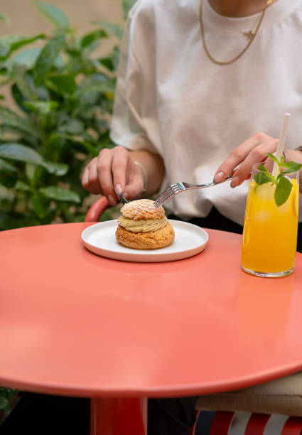 istock woman eats pastry choux in cafe 2153734395