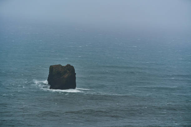 Cliff in the sea with strong waves in Iceland with copy space