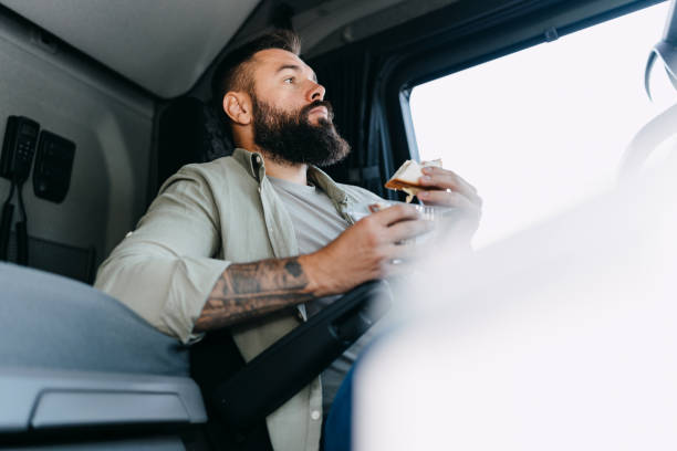 istock Man eating sandwich in truck cabin 2153739285