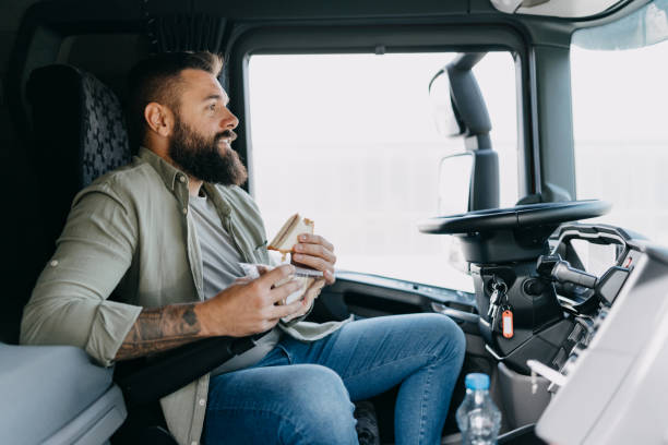istock Man using phone while sitting in truck cabin 2153739289