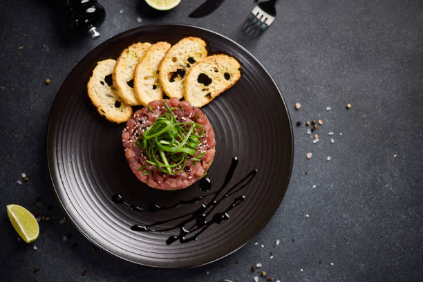 istock Tuna and avocado tartare on a dark ceramic plate 2153741211