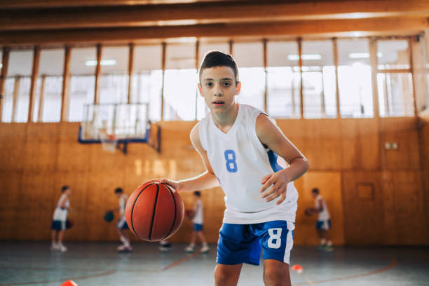 istock Basketball kid dribbling a ball on training and looking at camera. 2153741601