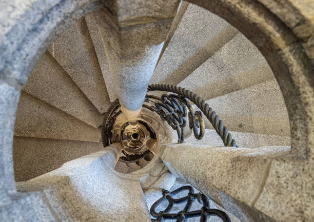 istock Upside view of The old stone spiral staircase with iron railing inside columnar structures. 2153744081
