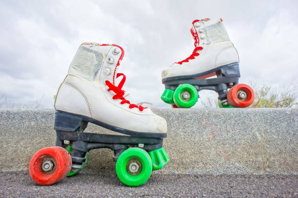 istock Two white roller skates with red laces are on a cement ledge 2153744242