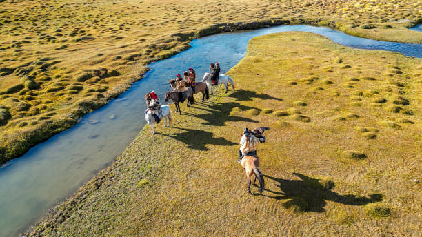istock eagle hunter leader joining group of Kazakh eagle hunters riding horses along river Bayan Olgii, West Mongolia 2153744514